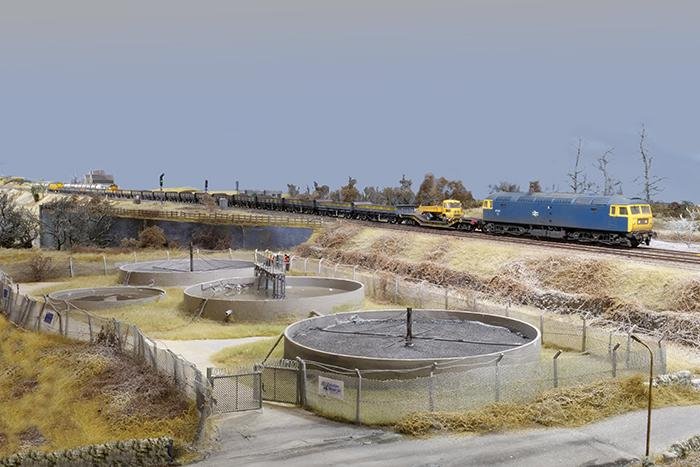 A Class 47 passes the sewage treatment plant on the approach to the bridge over the River Calder on Britain's Biggest Model Railway
